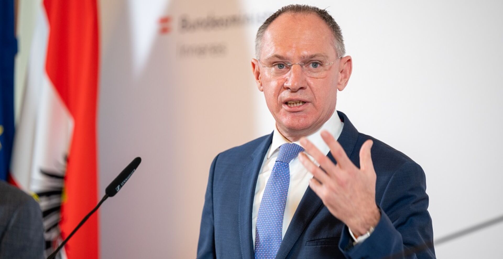 Innenminister Gerhard Karner vor der Pressewand des BMI. Er gibt eine Pressekonferenz