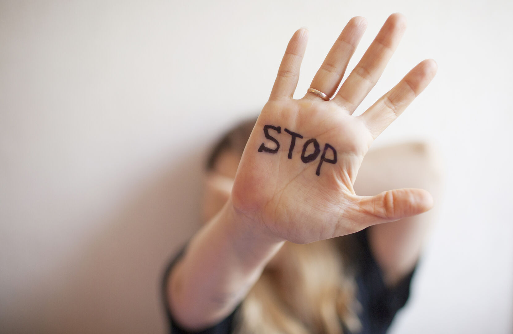 Frau zeigt ihre Hand, auf der "Stop" steht