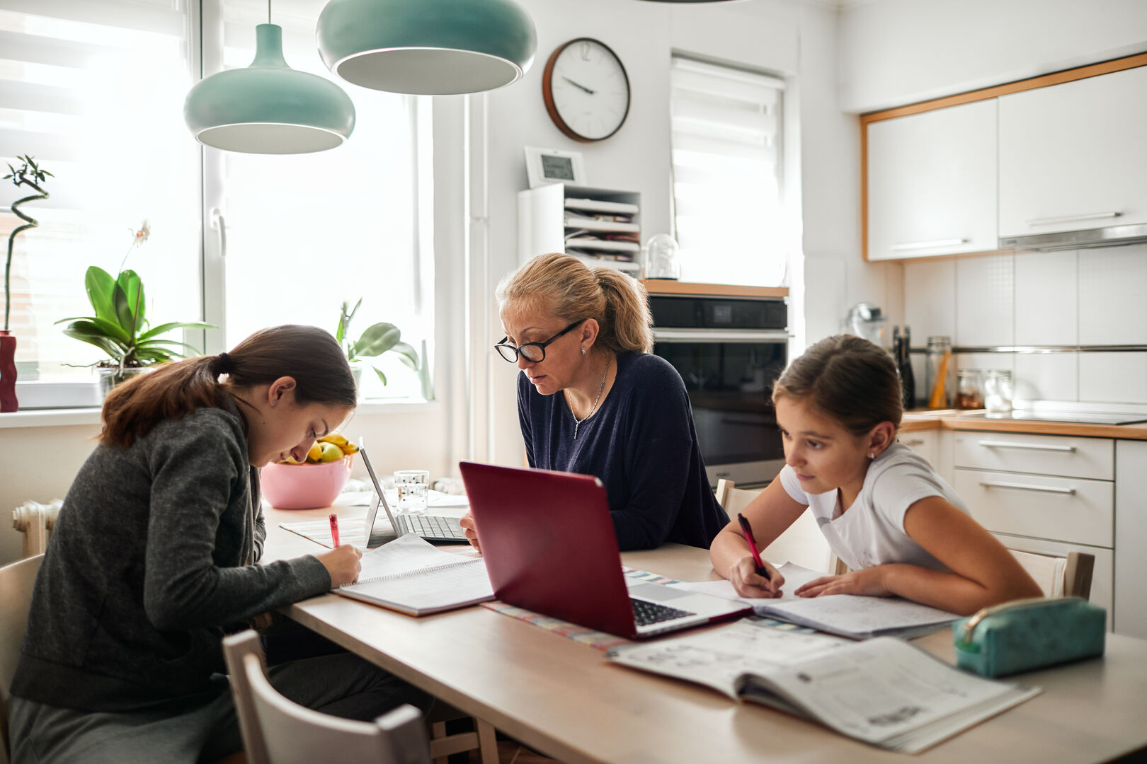 Mutter sitzt mit ihren Töchtern am Laptop