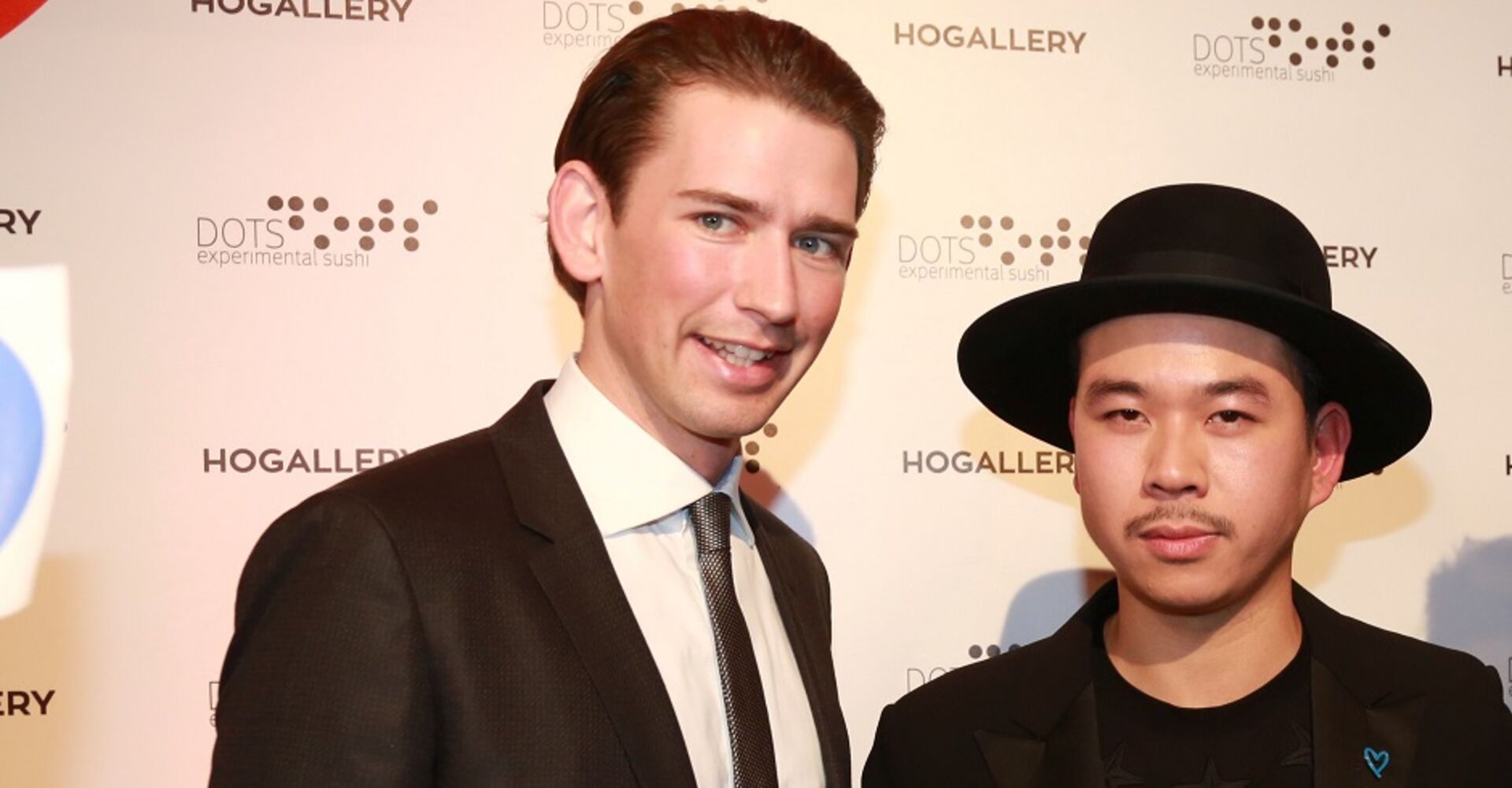 Sebastian Kurz und Martin Ho vor einer Fotowand der Ho Gallery