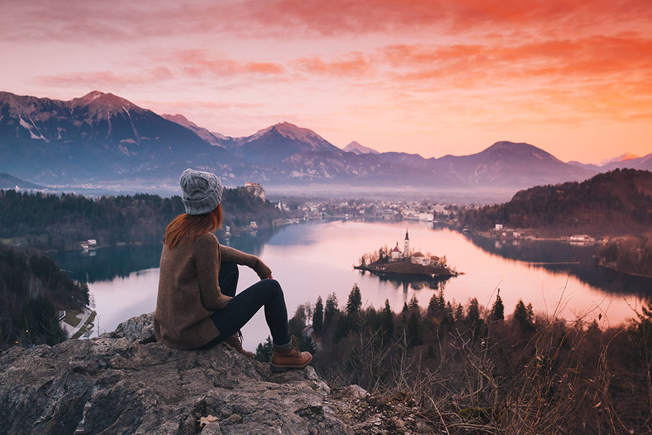 Junge Frau genießt den Blick von oben auf den Bleder See | Credit: iStock.com/NataliaDeriabina
