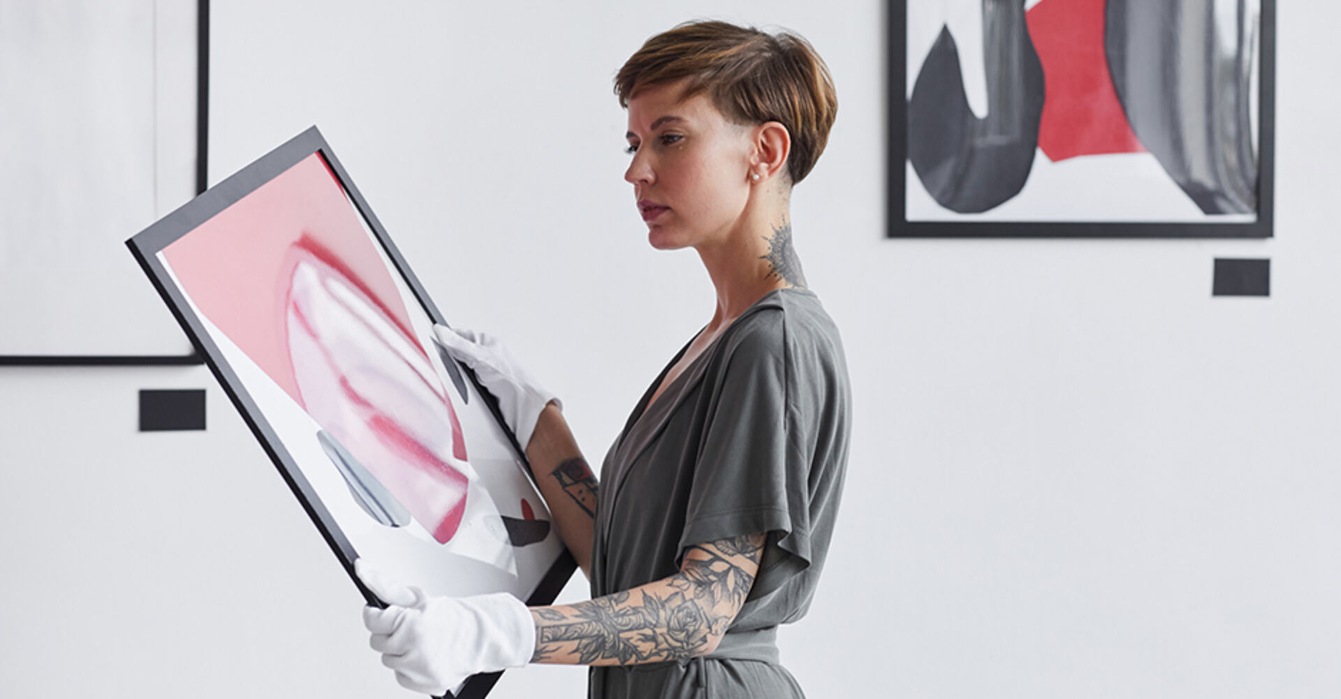 Junge Galeristin taxiert den Wert eines modernen Kunstwerks | Credit: iStock.com/SeventyFour