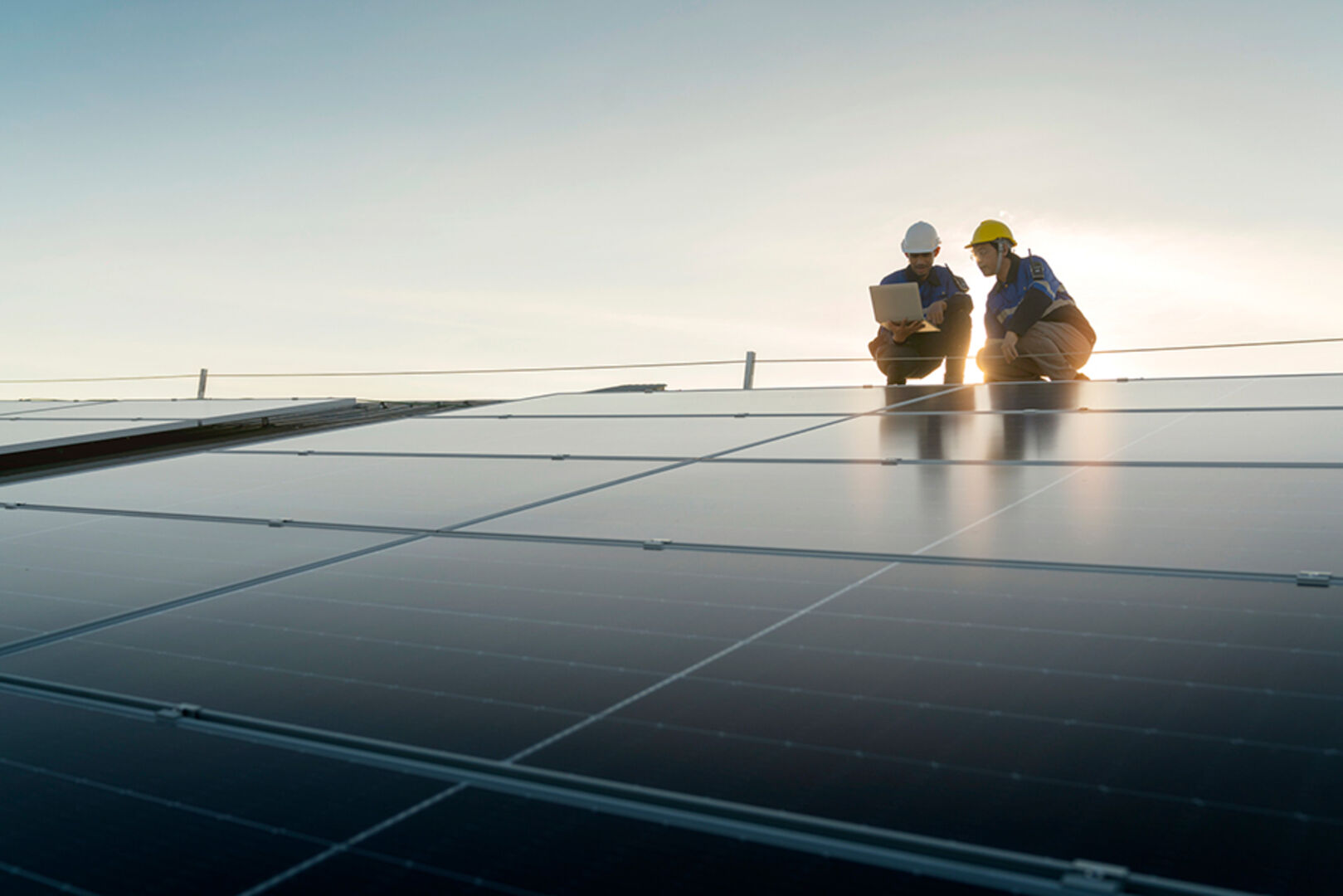 Zwei Monteure bei der Wartung einer Photovoltaik-Anlage | Credit: iStock.com/whyframestudio