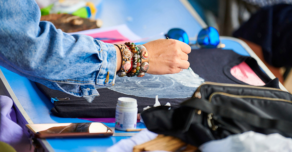 Junge Frau gestaltet ihr T-Shirt um | Credit: iStock.com/TRAVELARIUM