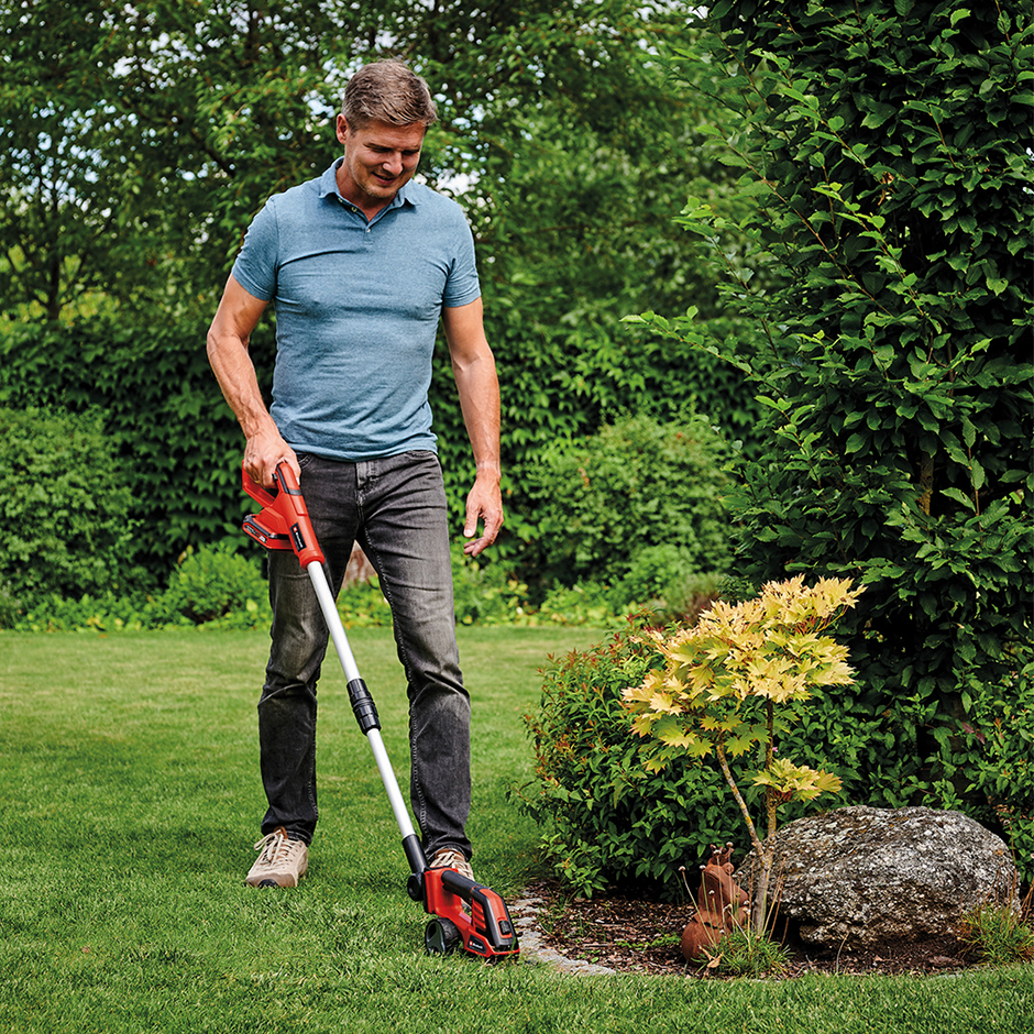 Mann bei der Gartenarbeit mit einem Akku-Rasentrimmer von EINHELL in der Hand | Credit: ZGONC
