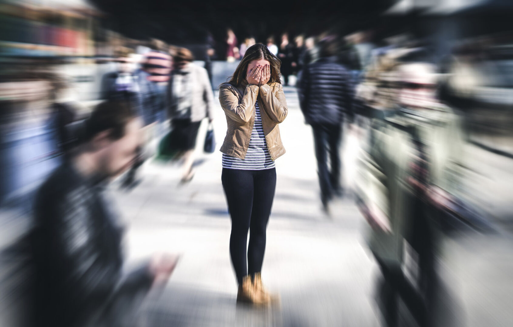 Frau steht allein in einer Menschengruppe | Credit: iStock.com/Tero Vesalainen