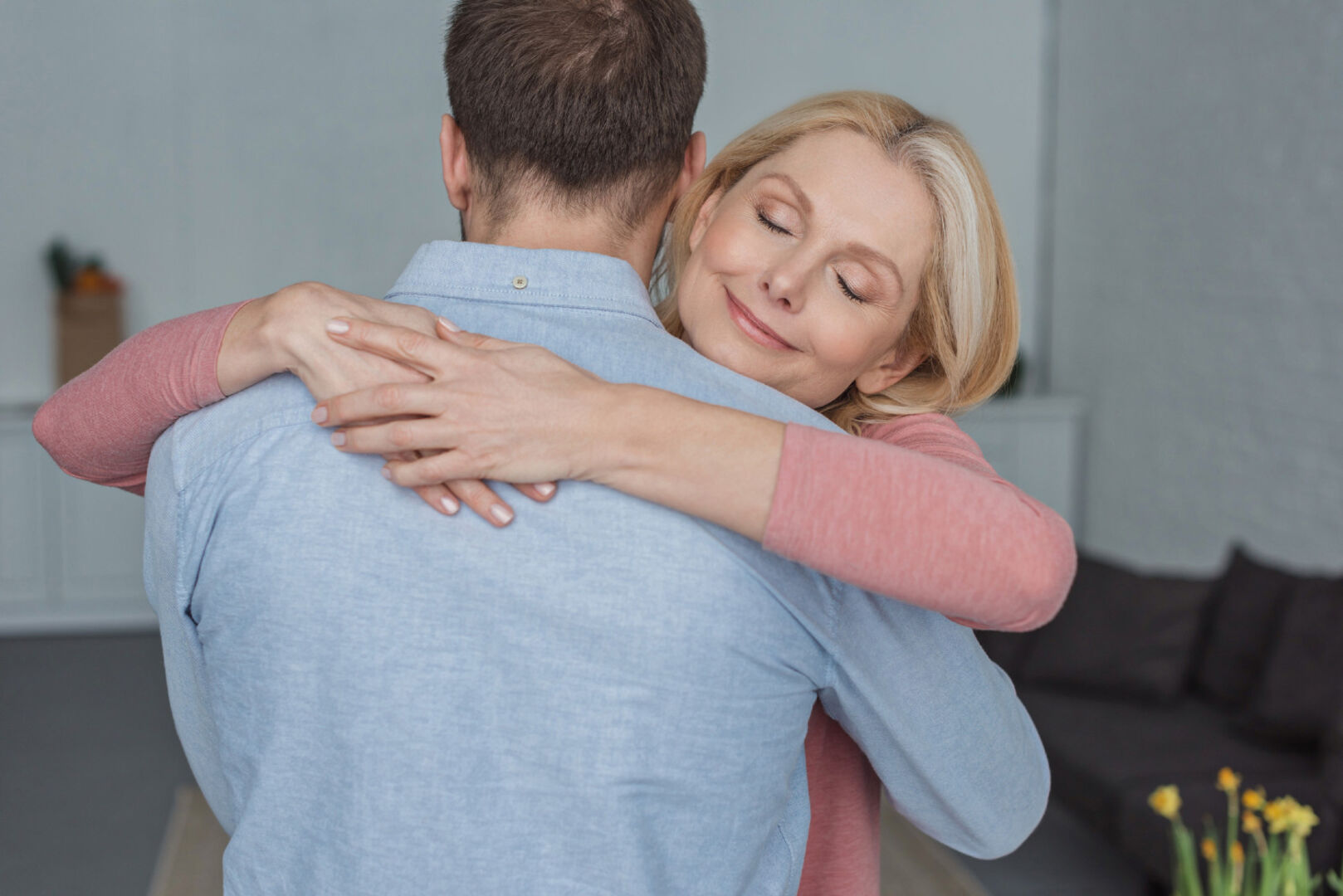 Ältere Frau umarmt jüngeren Mann | Credit: iStock.com/LightFieldStudios