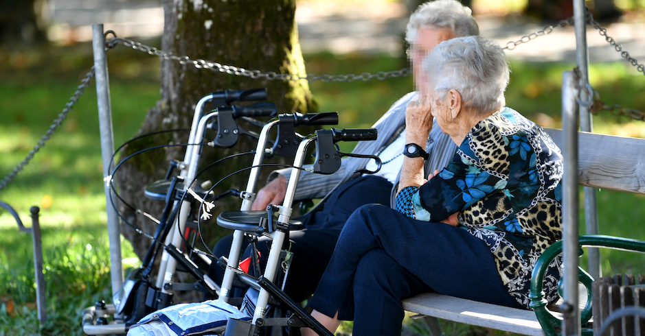 Ältere Menschen auf einer Parkbank im Sommer