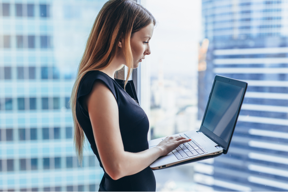 Junge Geschäftsfrau gibt Daten in ihren Notebook ein | Credit: iStock.com/undrey