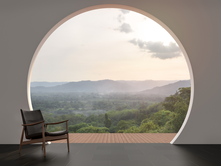 Rundes Fenster, das auf eine idyllische naturbelassene Landschaft weist | Credit: iStock.com/runna10