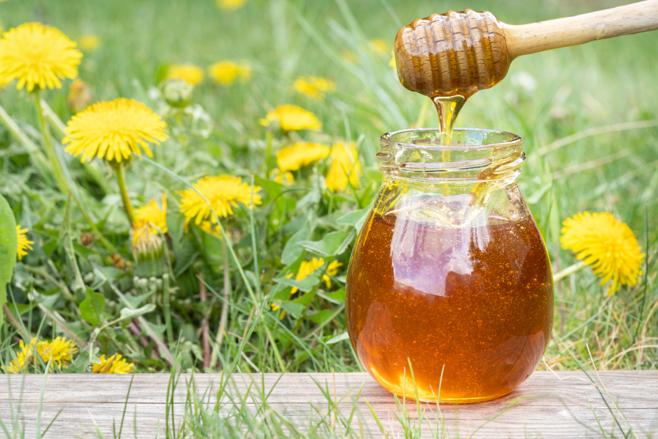 Ein Glas Honig  vor der Kulisse einer blühenden Sommerwiese | Credit: iStock.com/hopsalka
