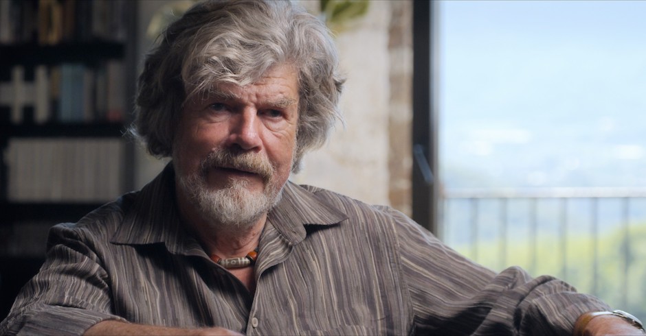 Porträt von Reinhold Messner vor einem Bücherregal.