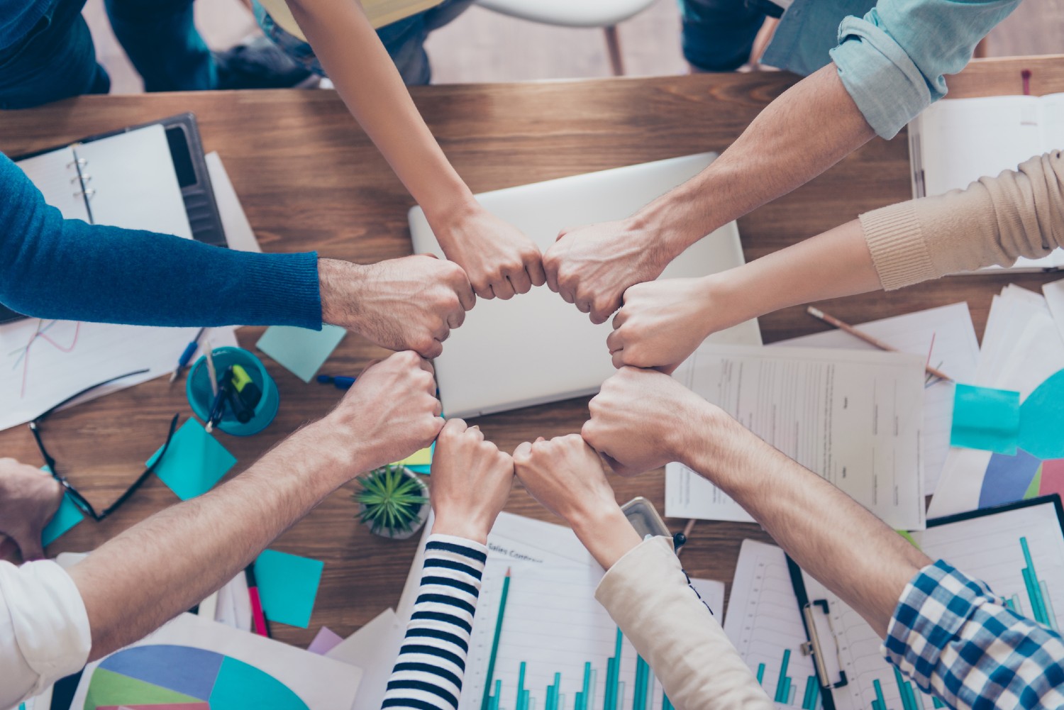 Mitarbeiter schlagen Fäuste aneinander | Credit: iStock.com/Deagreez