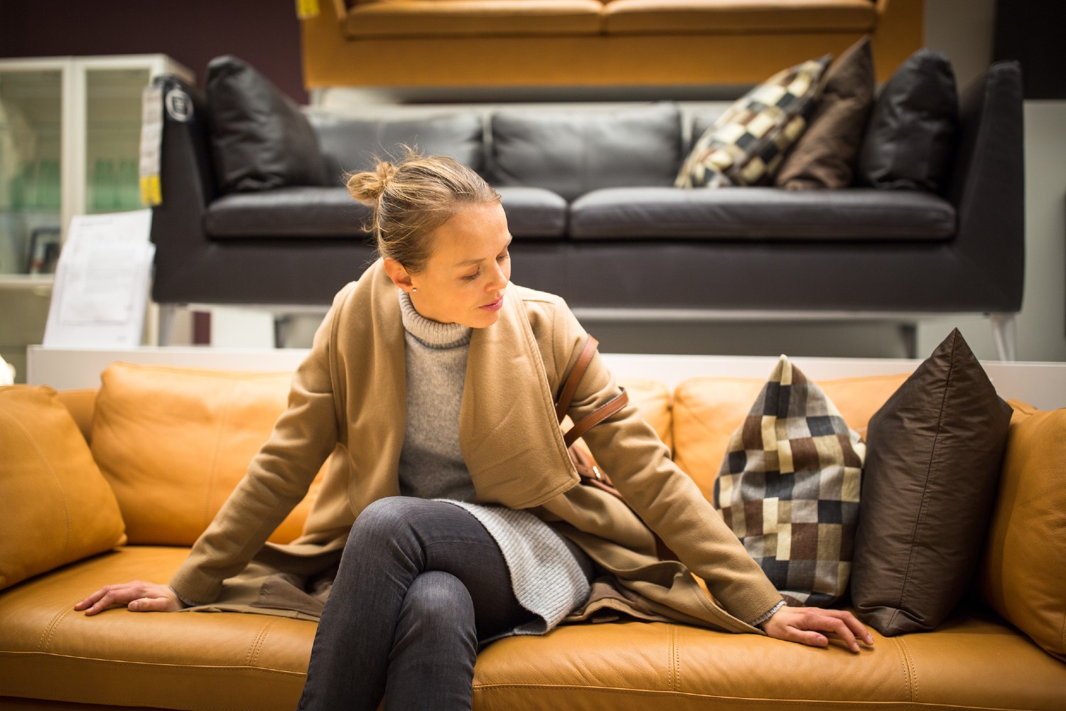 Frau sitzt auf einem gelben Sofa | Credit: iStock.com/ViktorCap