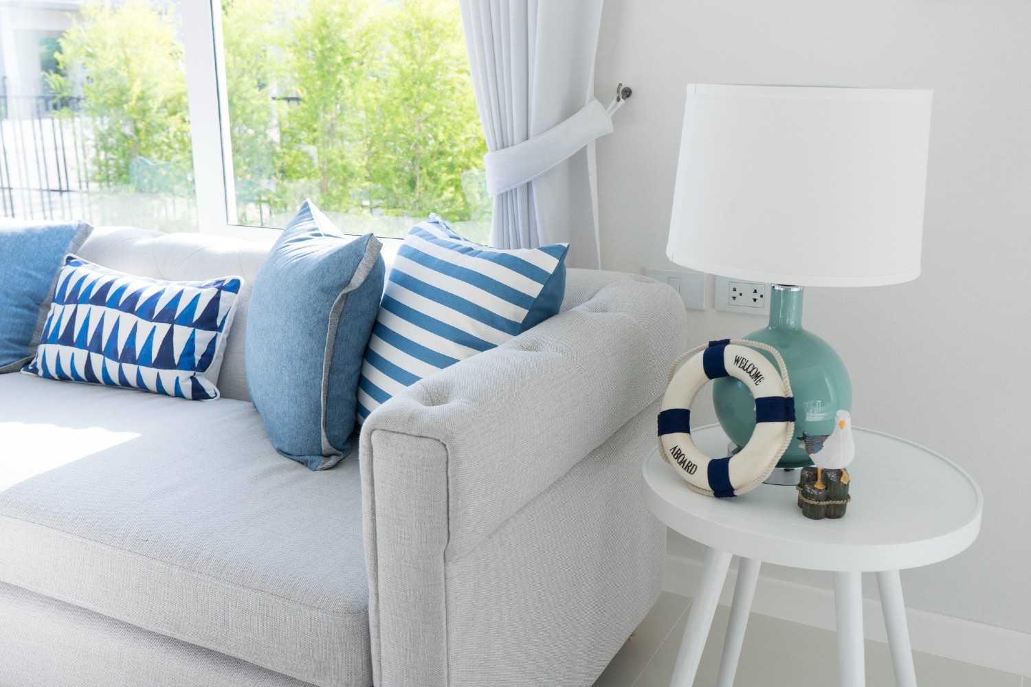 Graues Sofa mit blauen Zierkissen | Credit: iStock.com/ben-bryant