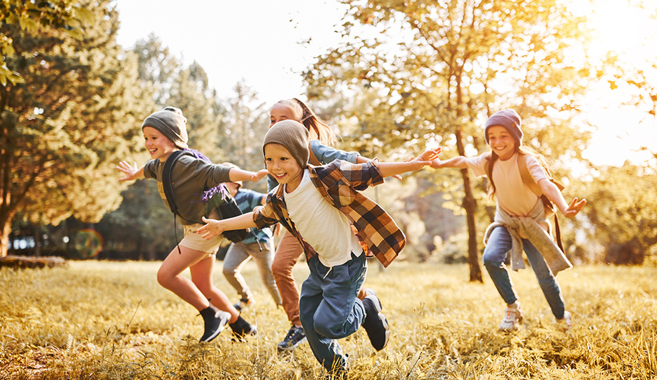 Kinder beim Herumtollen vor herbstlicher Kulisse | Credit: iStock.com/evgenyatamanenko