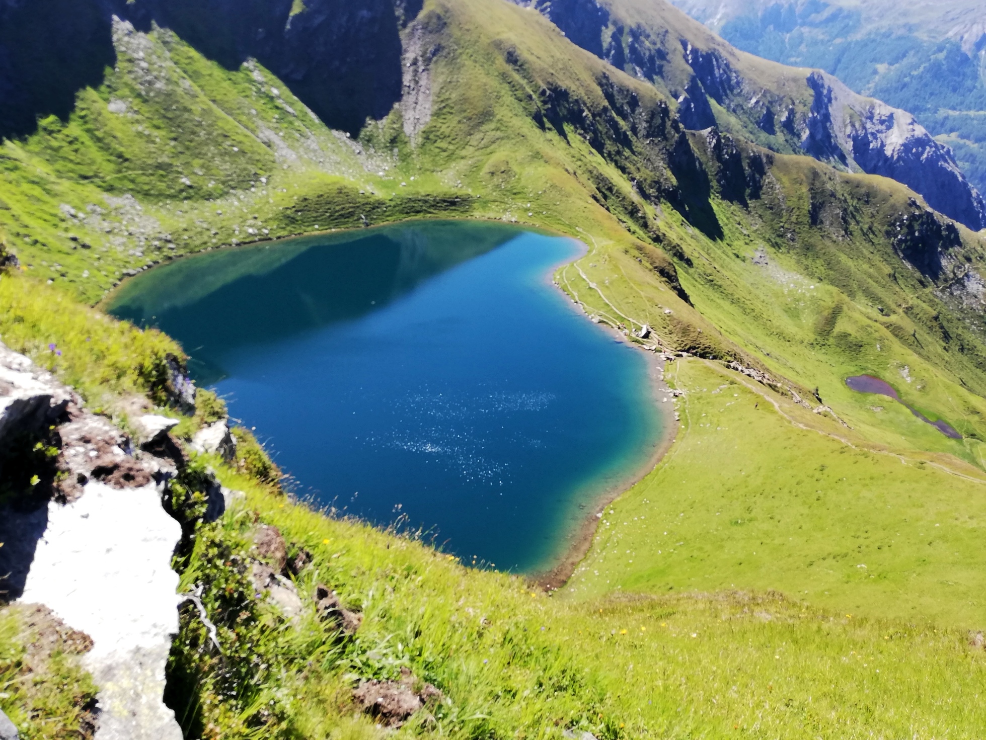 Blick auf den Twenger Almsee von oben. | Credit: Simone Reitmeier