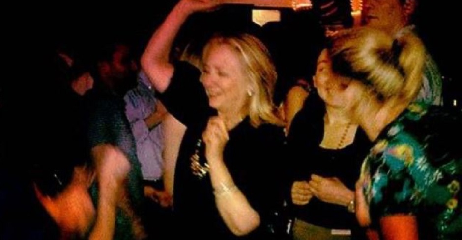 Eine verschwommene Aufnahme von Hillary Clinton. Es ist dunkel, sie tanzt, die Hände in der Luft.