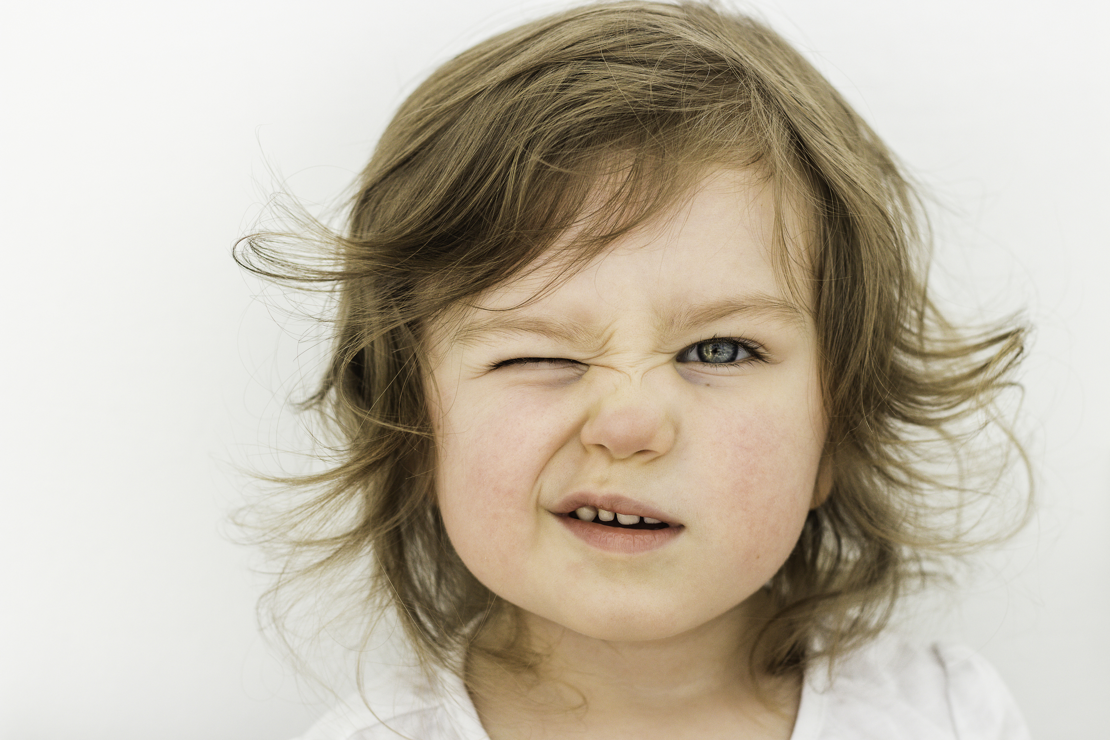 Kleines Mädchen kneift ein Auge zusammen. | Credit: iStock.com/Olga Ignatova