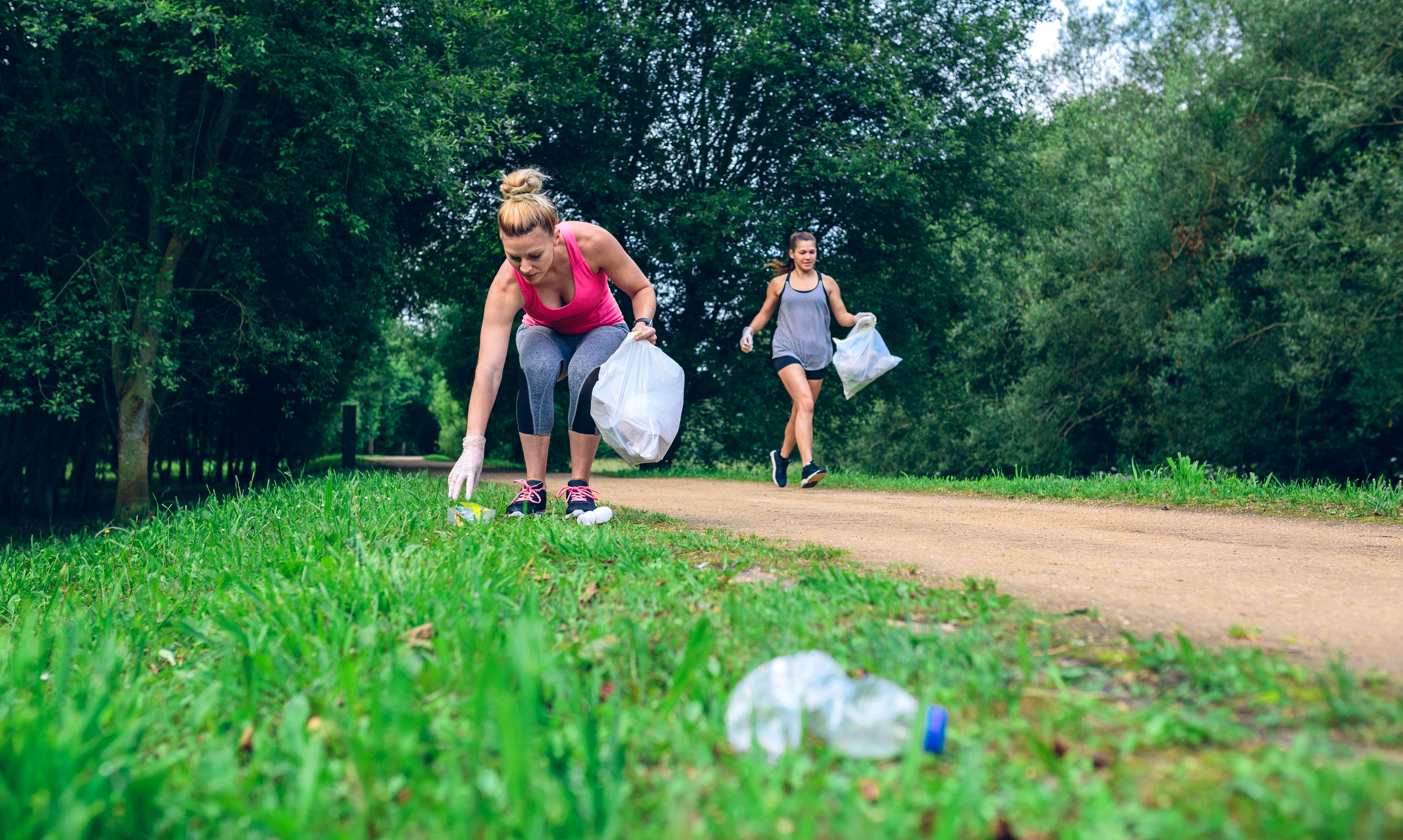 Frauen joggen und sammeln Müll ein | Credit: iStock.com/doble-d