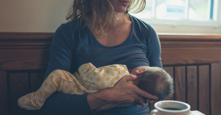 stillende Mutter sitzt auf einer Holzbank | Credit: iStock.com/lolostock