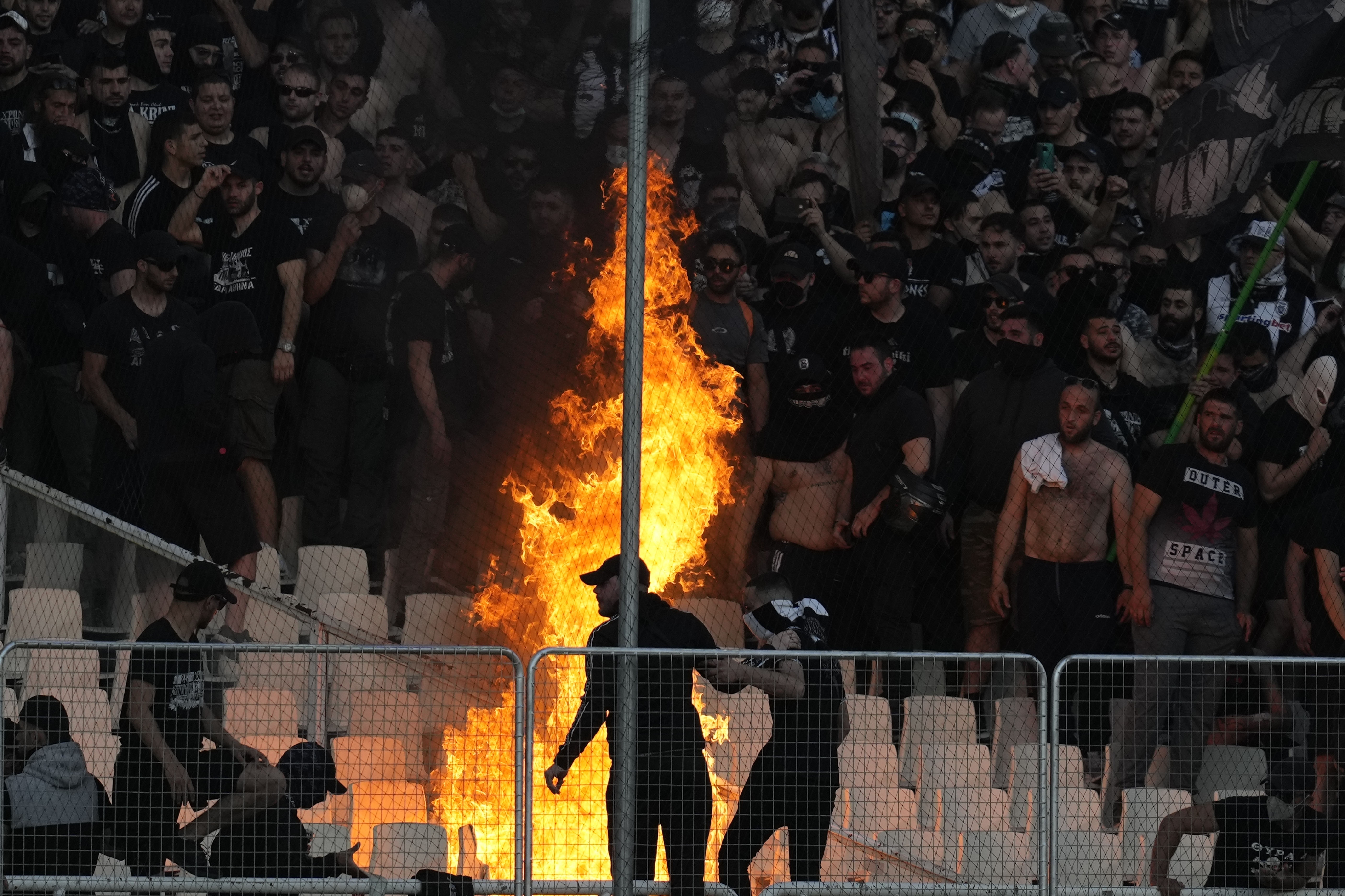 Hooligans, die auf einer Fußballtribüne ein Feuer entfacht haben.