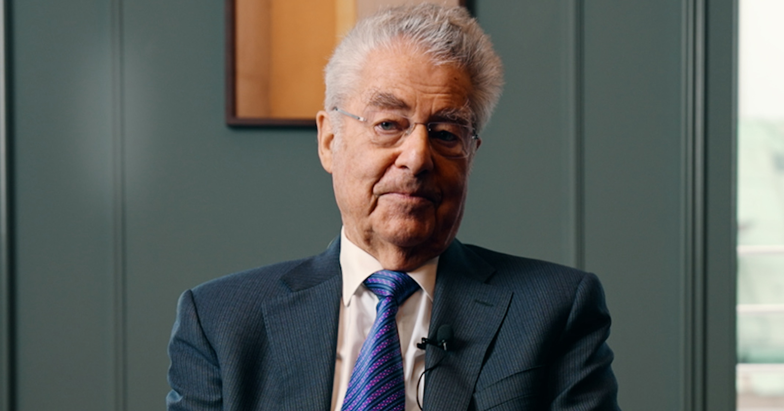 Ein Screenshot aus der Videobotschaft von Heinz Fischer. Der ehemalige Bundespräsident trägt Krawatte und sieht freundlich frontal in die Kamera.