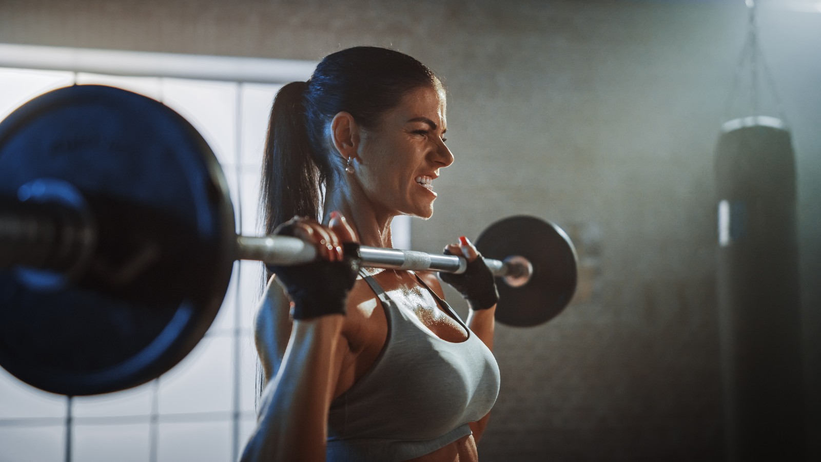 Frau trainiert mit Langhantel | Credit: iStock.com/gorodenkoff
