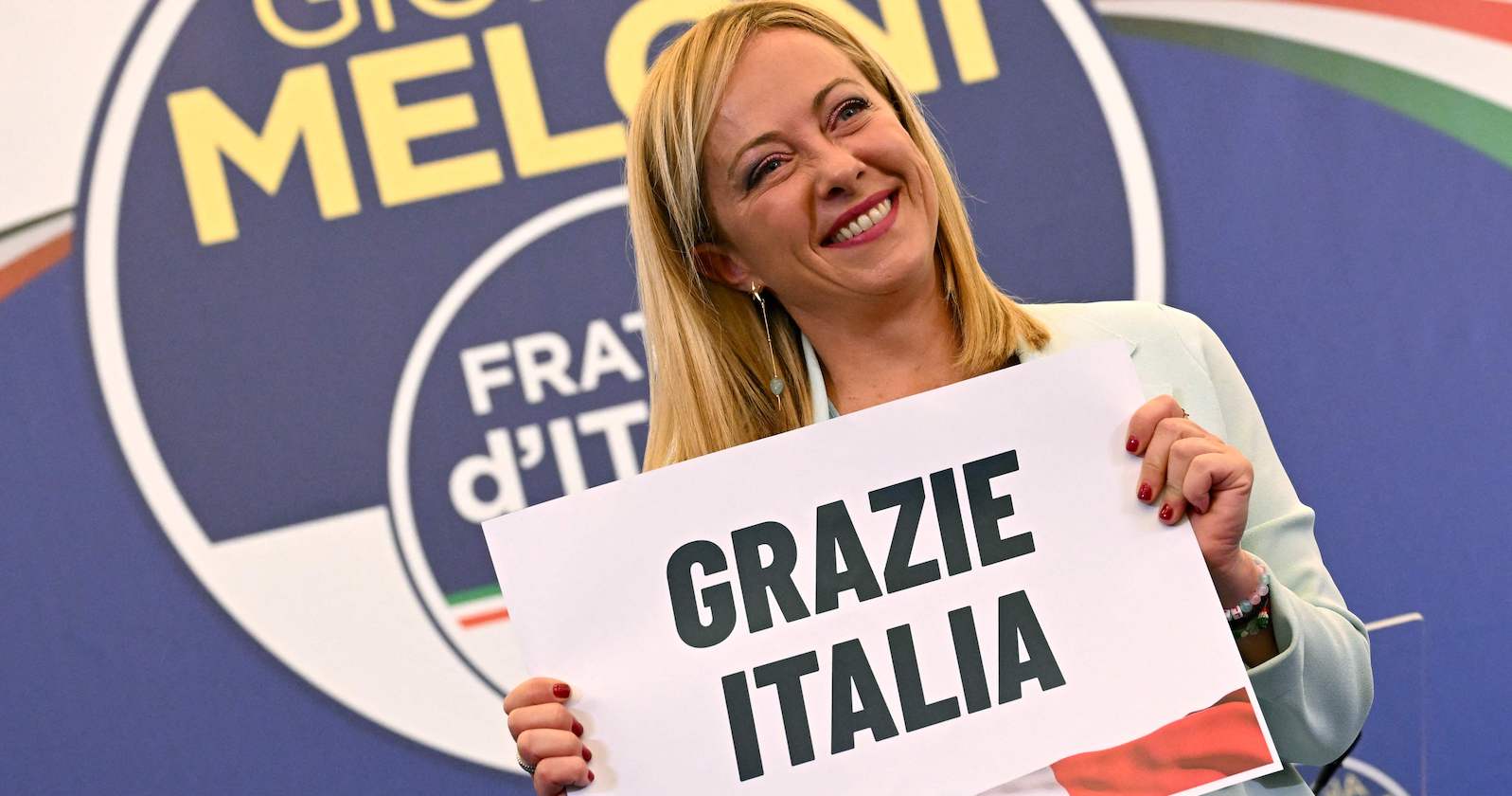 Parteichefin Meloni mit einem Schild "Grazie Italia"