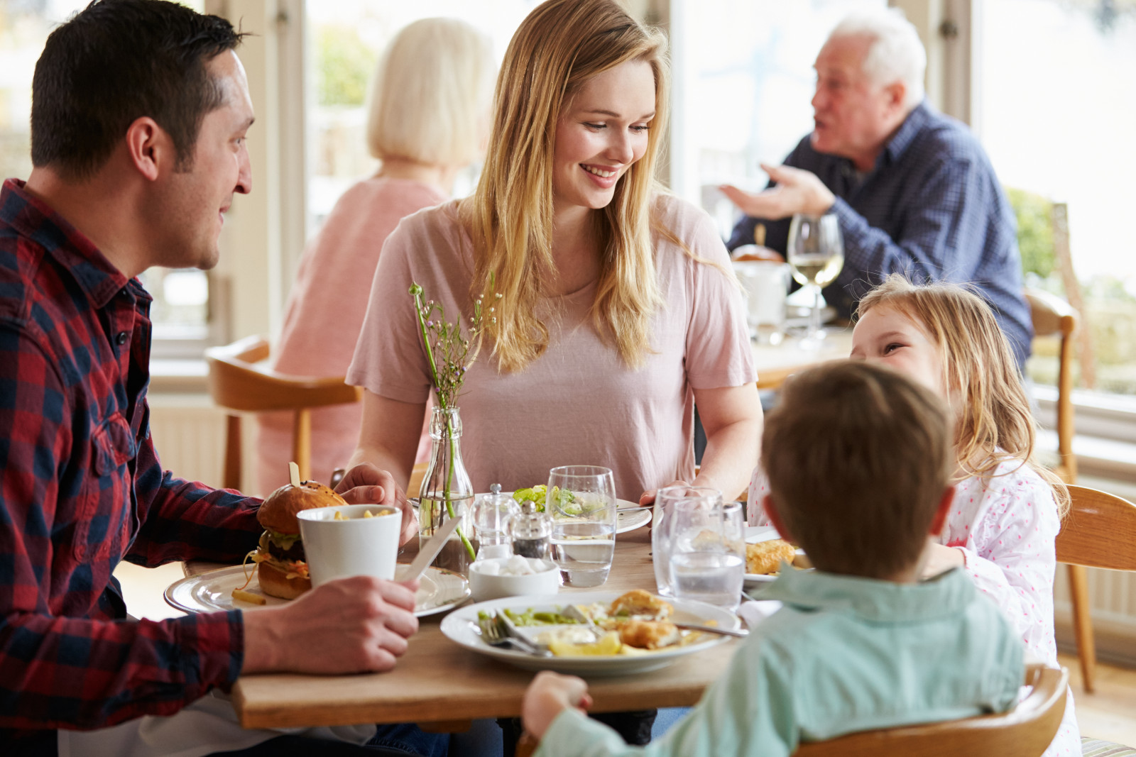 Familie isst gemeinsam im Restaurant | Credit: iStock.com/monkeybusinessimages