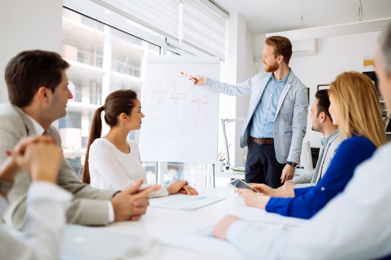 Mann steht fur Gruppe von Mitarbeitern | Credit: iStock.com/nd3000