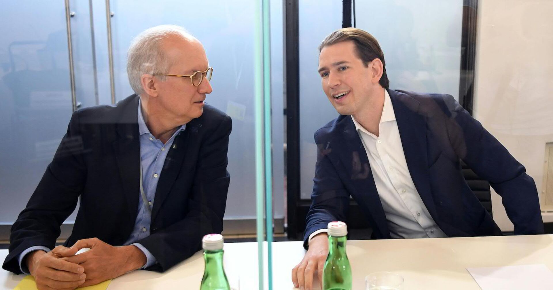 Porträt von beiden, nebeneinander sitzend und miteinander sprechend