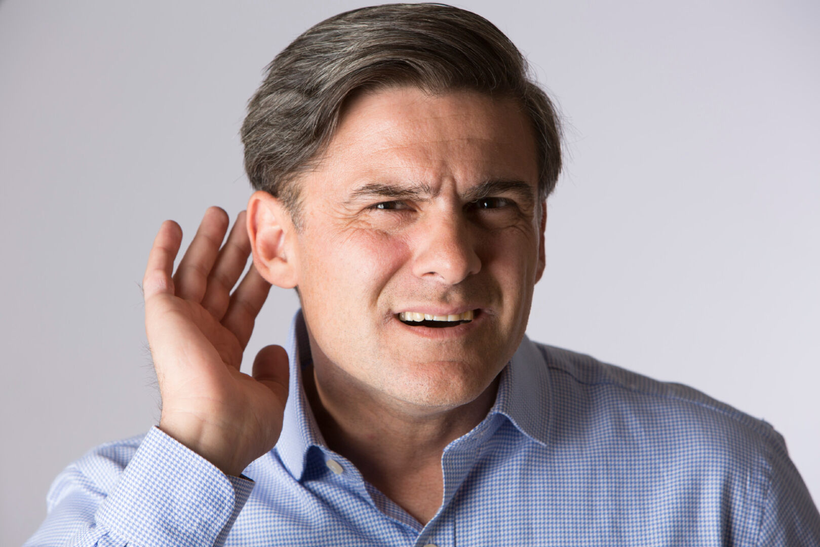 Mann hält sich Hand an sein Ohr | Credit: iStock.com/Daisy-Daisy