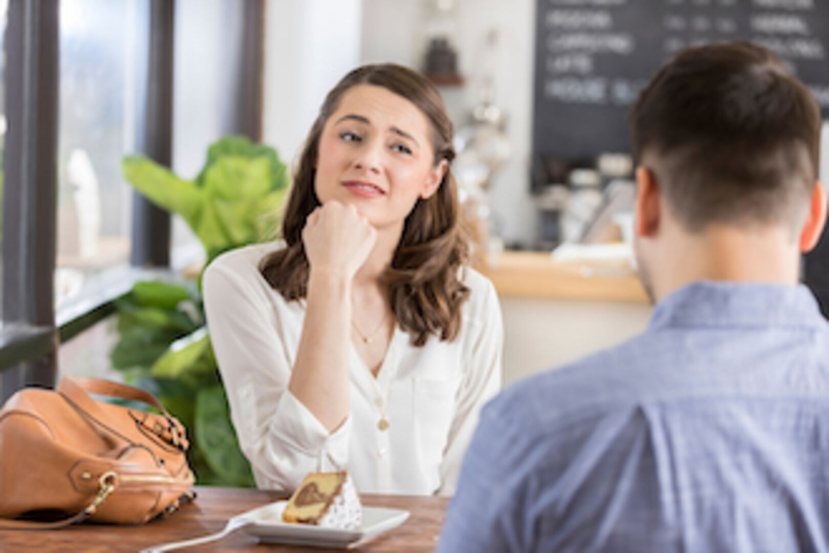 Eine junge Frau schaut skeptisch bei einem Date