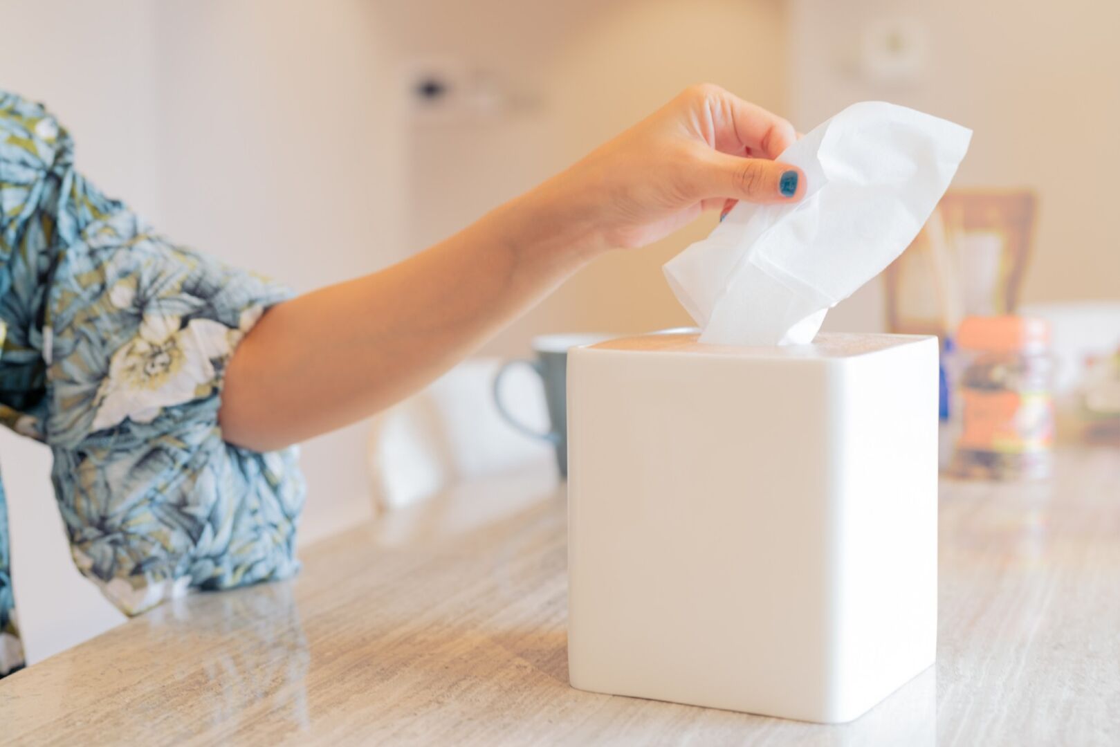 Frau nimmt ein Taschentuch aus einer Box | Credit: iStock.com/PORNCHAI SODA