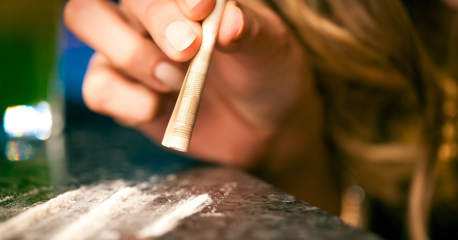 Frau schnupft mit einem Geldschein Kokain | Credit: iStock.com/kzenon