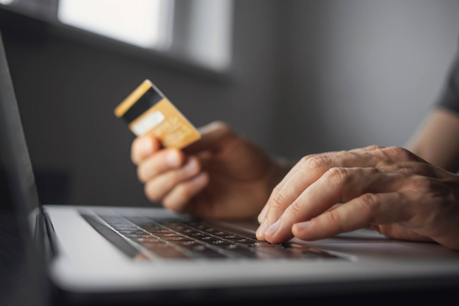 Mann bezahlt online mit Kreditkarte | Credit: iStock.com/Poike