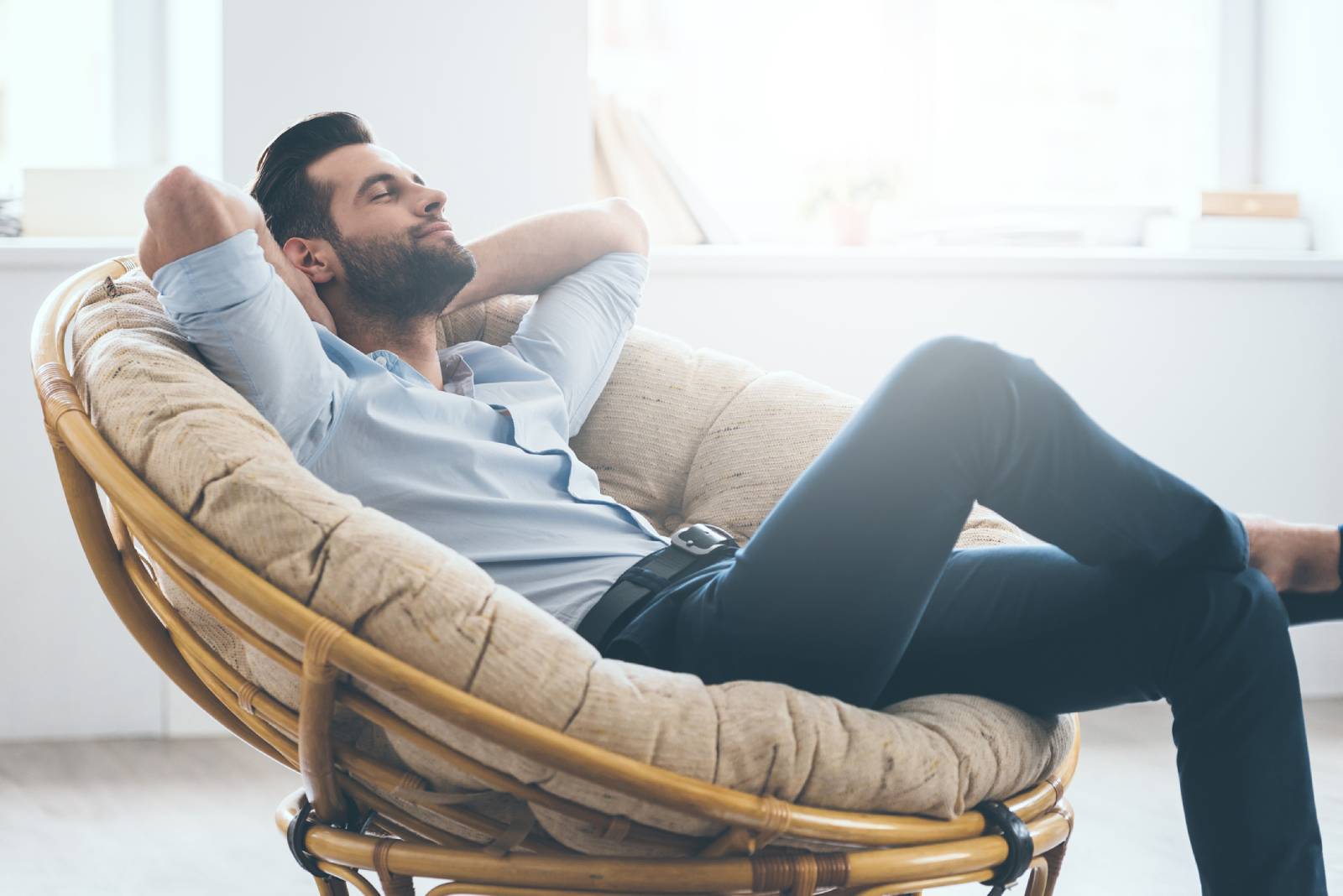 Mann lehnt entspannt in seinem Sessel mit geschlossenen Augen | Credit: iStock.com/g-stockstudio