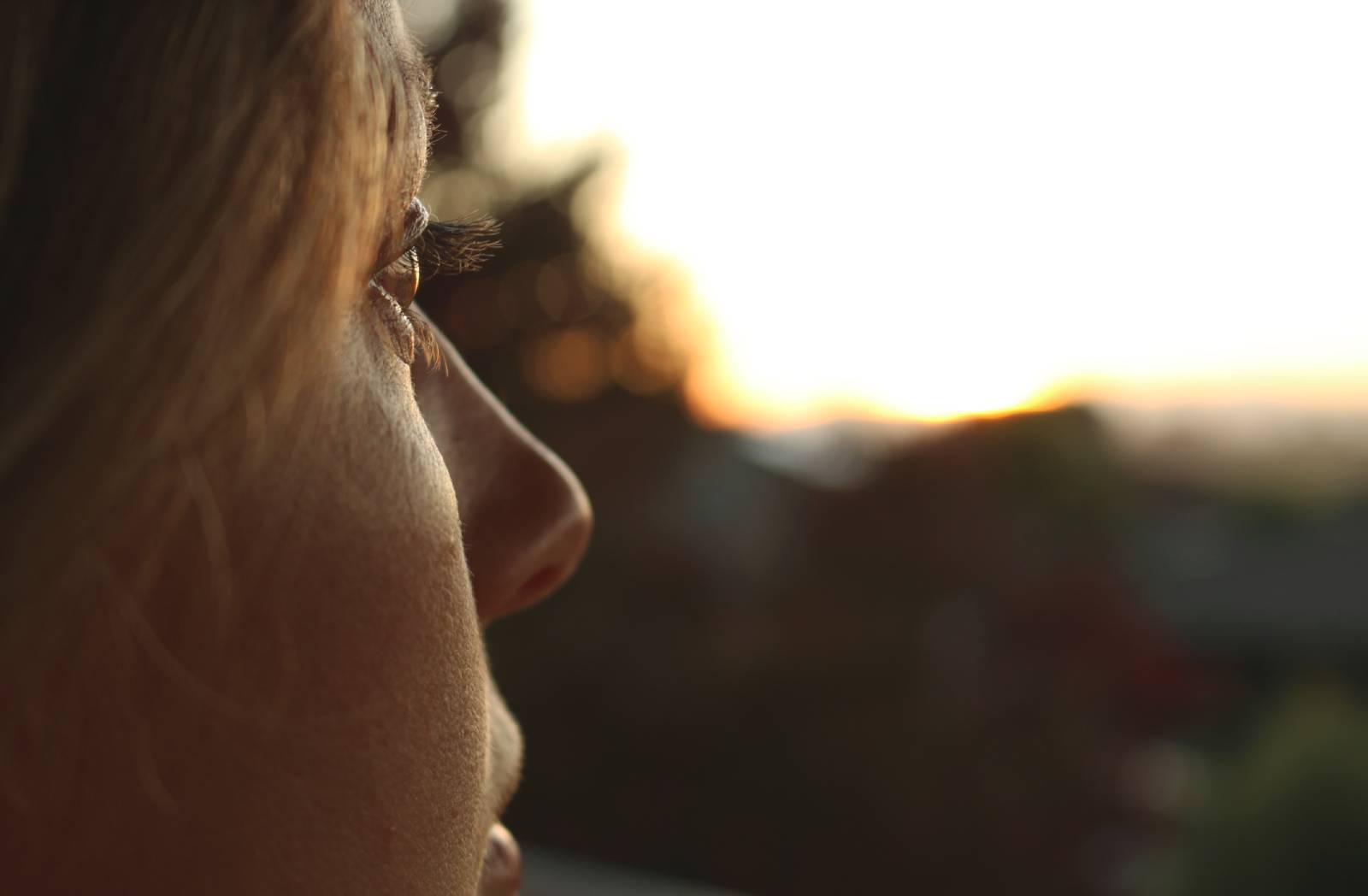Junge Frau blickt nachdenklich in die Ferne | Credit: iStock.com/LucidSurf