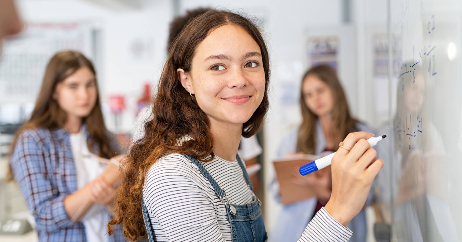 Schülerin schreibt etwas auf die Tafel | Credit: iStock.com/Ridofranz