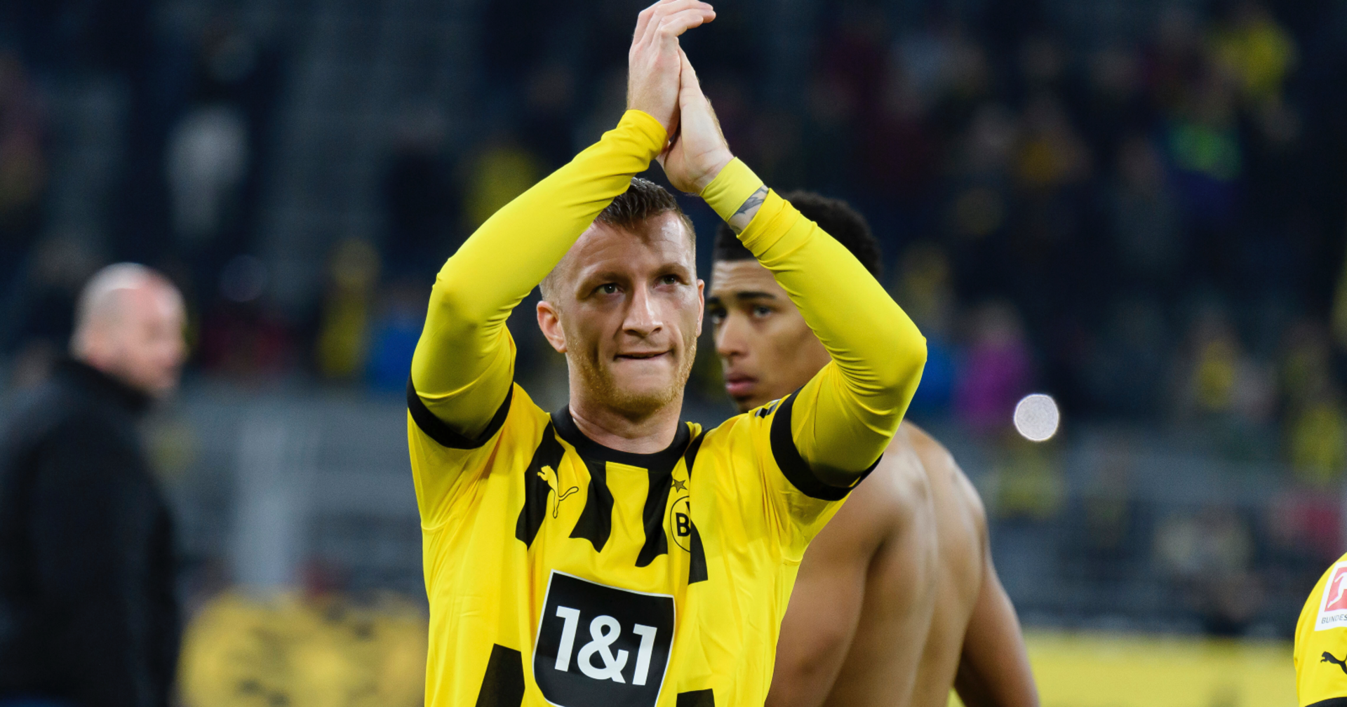 Marco Reus im Dress des BVB, der mit über seinen Kopf erhobenen Händen dem Publikum zujubelt