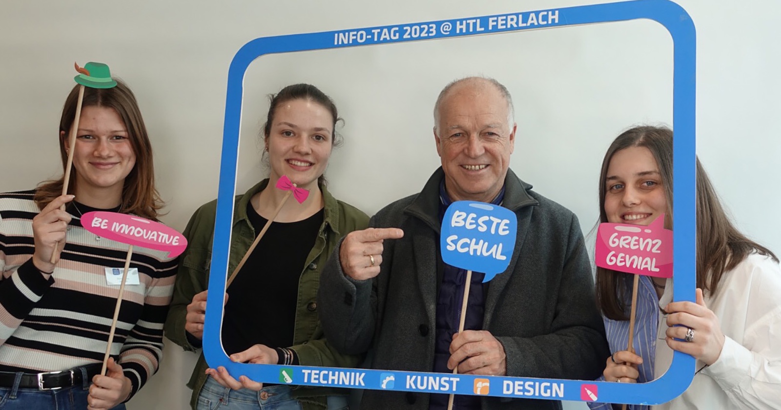 Der Ferlacher Bürgermeister und drei HTL-Schülerinnen, die einen überdimensionalen Bilderrahmen sowie an Sprechblasen erinnernde Werbeschilder in die Höhe halten
