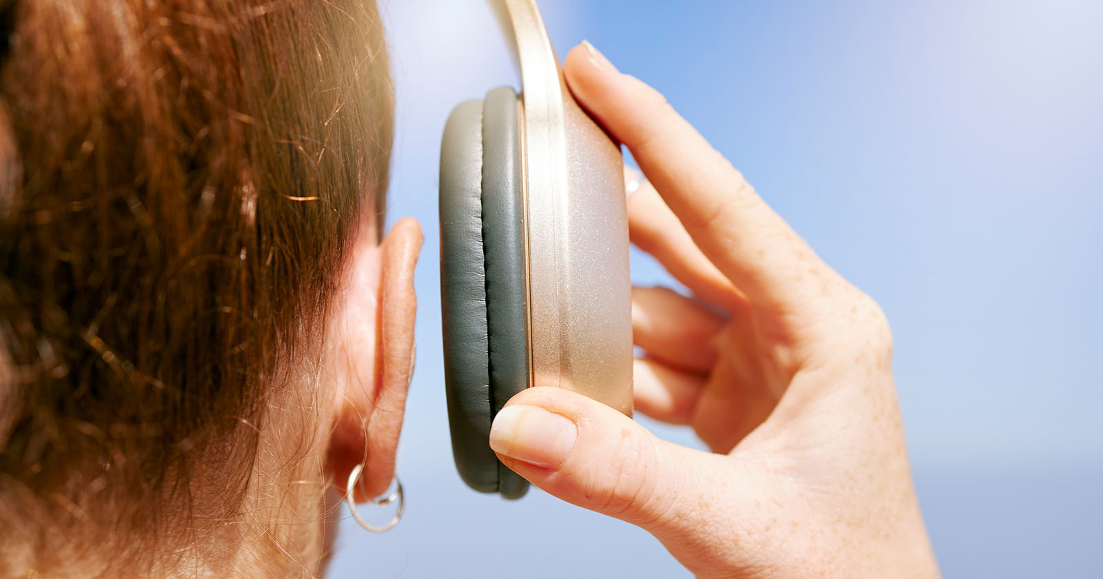 Frau setzt einen Kopfhörer auf