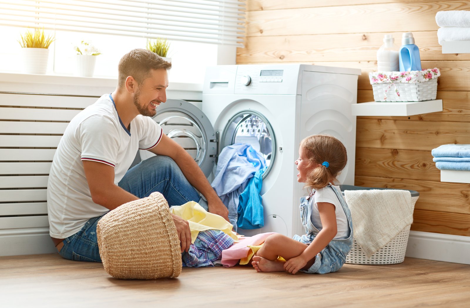 Vater und Tochter waschen zusammen Wäsche | Credit: iStock.com/evgenyatamanenko