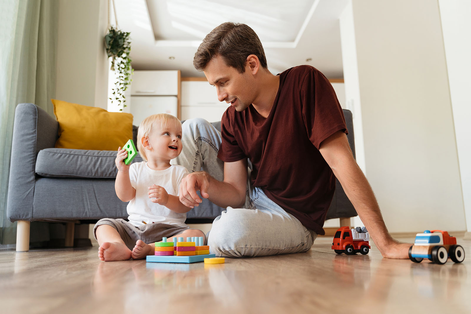 Ein junger Mann spielt mit einem Kleinkind | Credit: iStock.com/Arsenii Palivoda