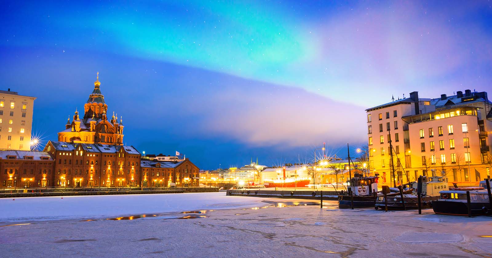 Nordlichter über dem gefrorenen Hafen im Stadtteil Katajanokka | Credit: iStock.com/Delpixart