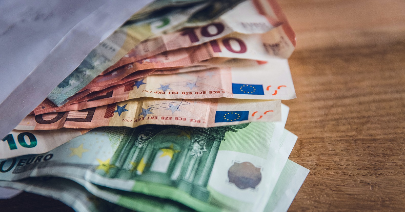 Ein Kuvert mit mehreren Bargeld-Scheinen von10 bis 100 Euro.