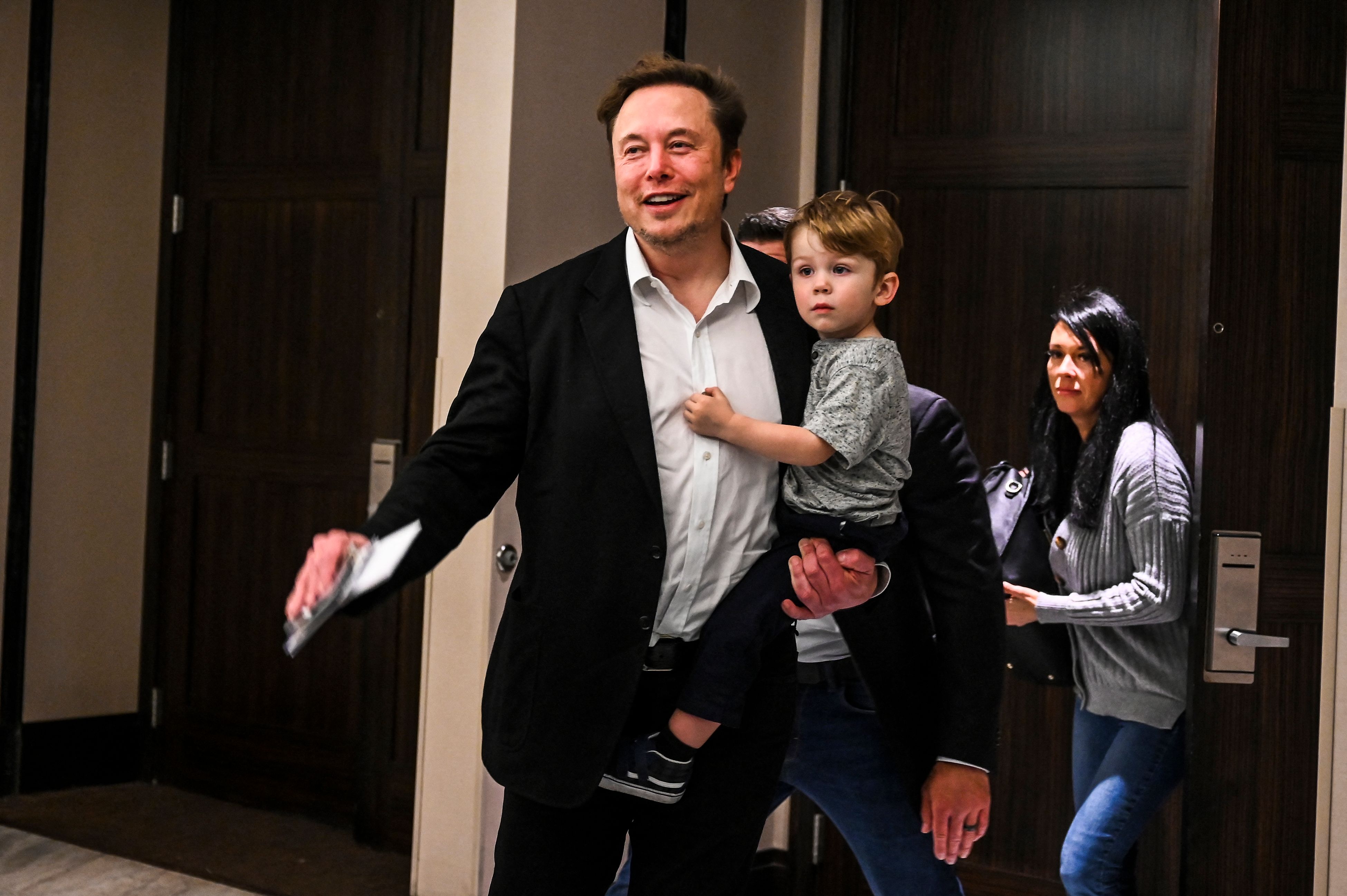 Elon Musk hält X Æ A-XII auf dem Arm.
