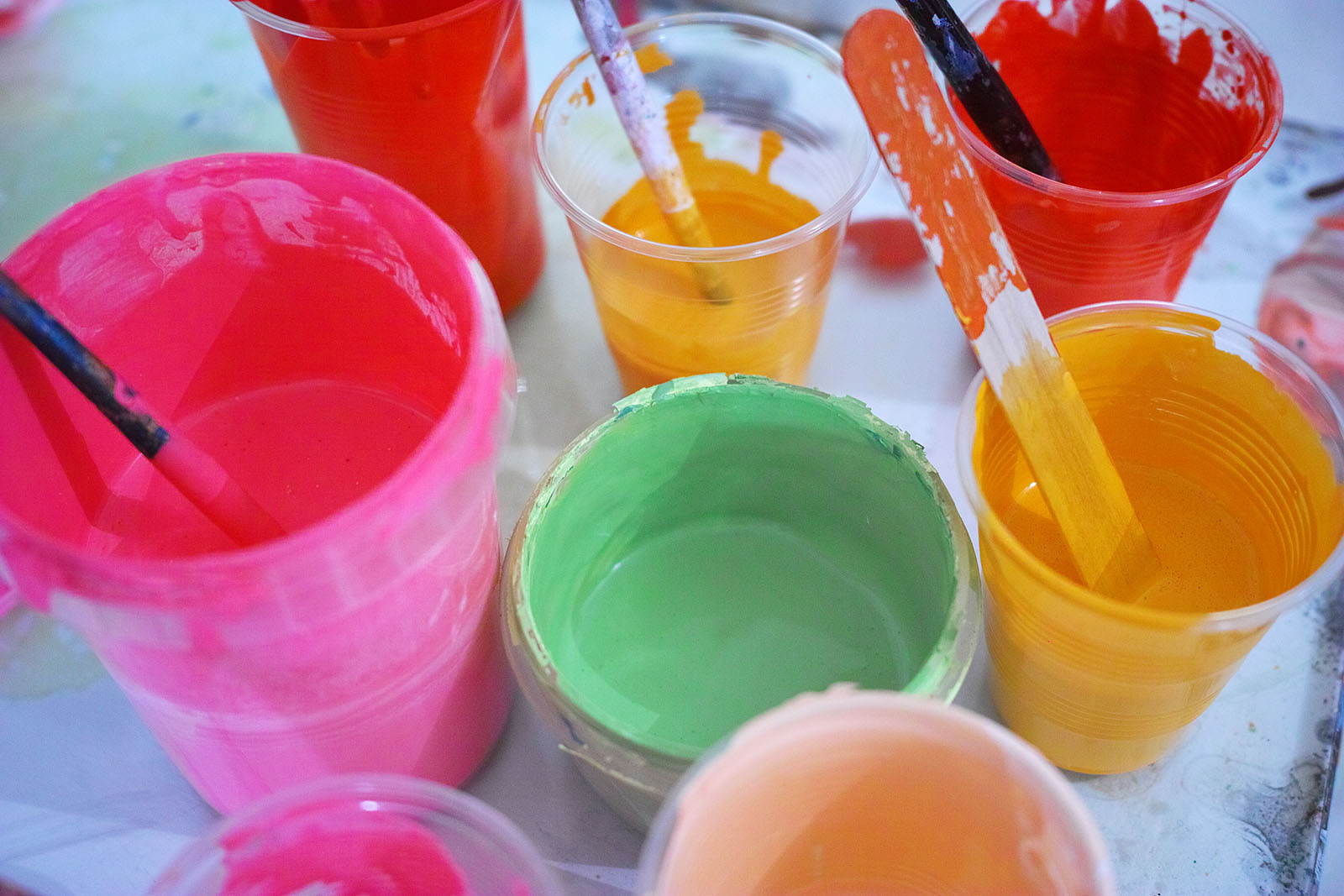 Acrylfarben stehen in Bechern auf einem Tisch | Credit: iStock.com/kolaybirsey