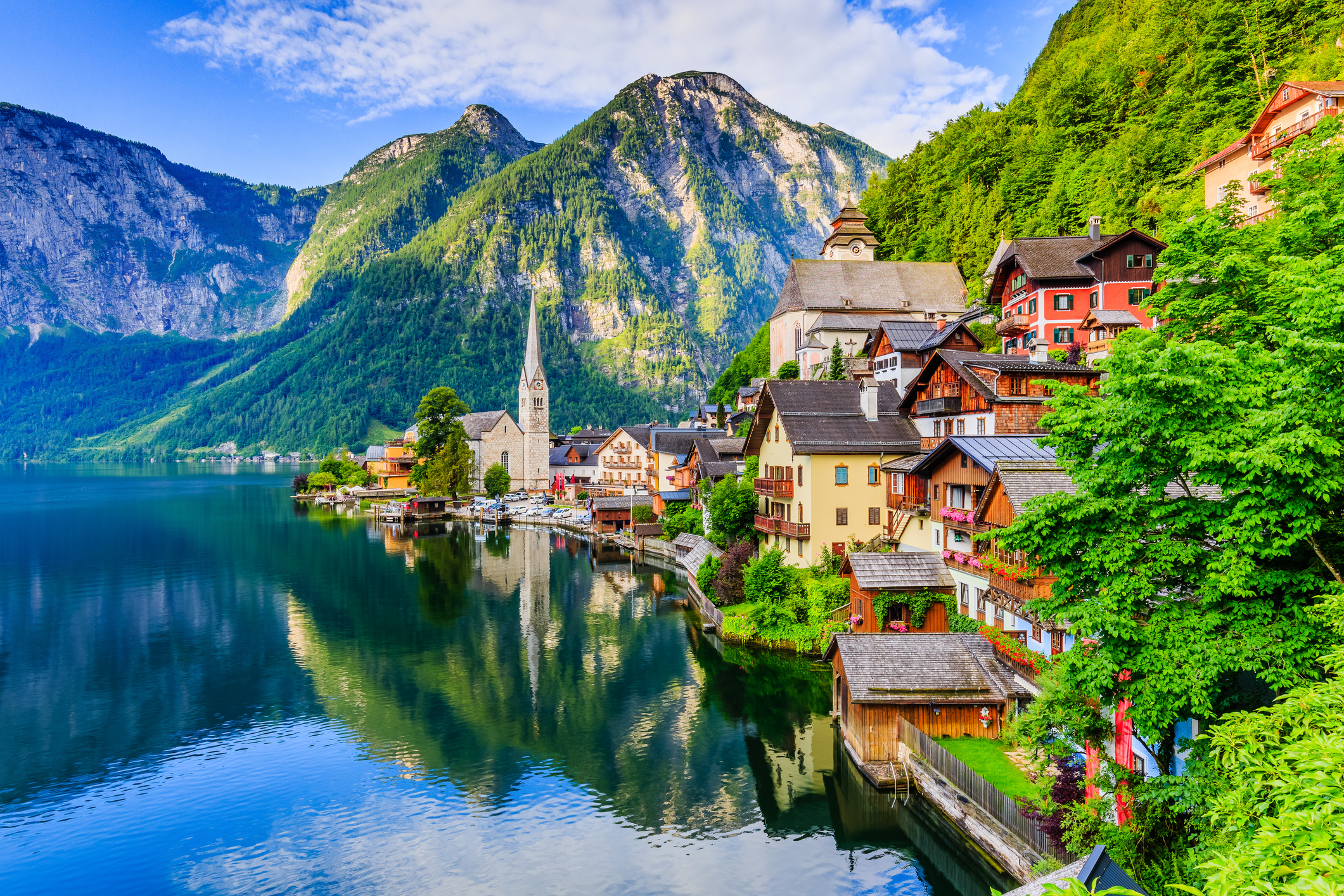 Panoramaaufnahme von Hallstatt inmitten einer Landschaftskulisse aus Bergen und einem See